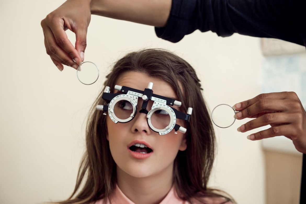 An optometrist carrying out a sight test with a phoropter during an eye examination
